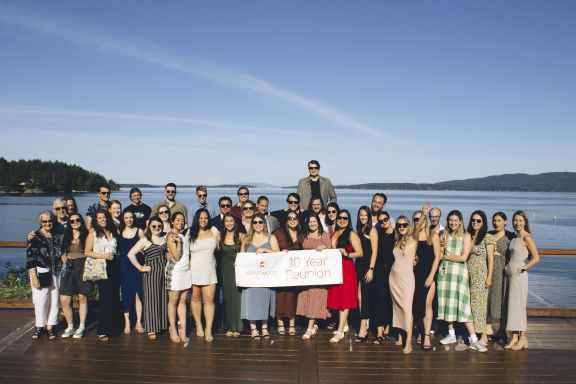 An alumni grad class posing for their ten year reunion photo