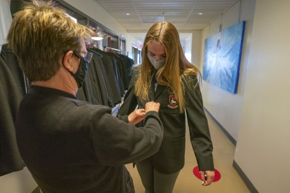 Brentwood's head seamstress helps fit a student with a new blazer