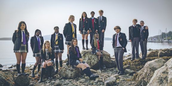A group of students in uniform at the oceanfront