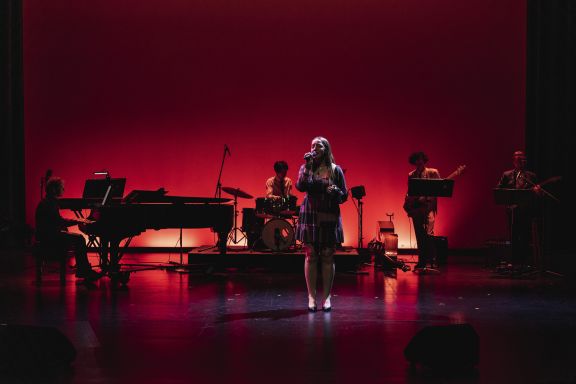 A singer performing on stage with a band